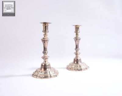 pair of silver candlesticks on a white surface with a white background