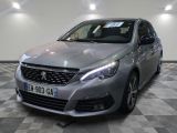 La voiture argentée est garée dans le showroom, sur le sol à damier.