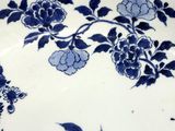 a blue and white plate with flowers and birds on it