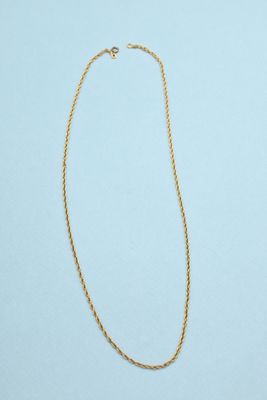 a gold necklace with a chain on a blue background