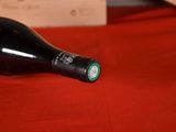 a bottle of wine sitting on a red table cloth
