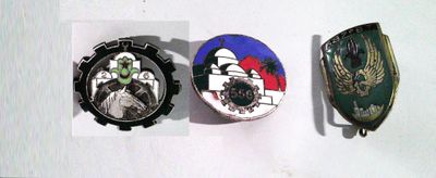 trois insignes sur un fond blanc ; l'un comporte une horloge et l'autre une image