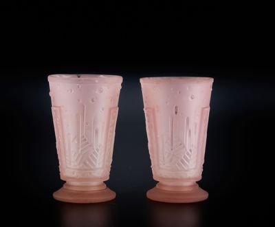 une paire de vases en verre rose sur fond noir