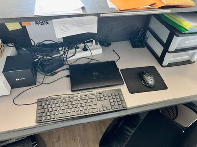 un bureau d'ordinateur sur lequel se trouvent un clavier, une souris et d'autres objets
