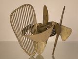 une sculpture métallique représentant une hélice, posée sur une table