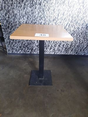 une petite table sur laquelle est posé un panneau, devant un mur