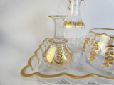 des bouteilles et des verres posés sur un plateau, sur fond blanc
