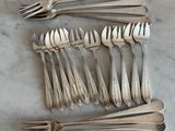 many forks and spoons laid out on the table