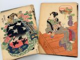 two old books with asian designs on them on a table