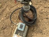 un compteur d'eau et un tuyau d'arrosage posé par terre