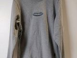 grey sweatshirt hanging on a hanger on a wall in a room