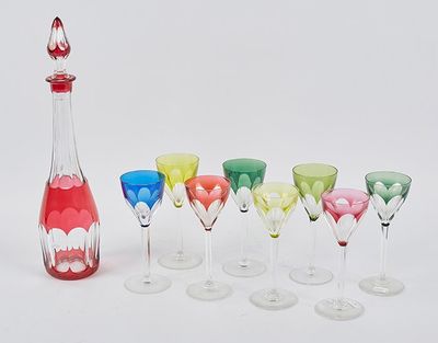bottles and glasses are lined up in a row on a white surface