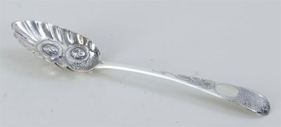 cuillère en argent ornée d'un motif représentant un hibou sur un fond blanc