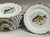 de nombreuses assiettes ornées de poissons, posées sur une table