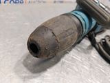 a corded drill that is sitting on a table