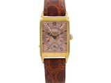 an image of a gold and brown watch on a white background