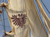 un drapeau orné d'un oiseau, hissé sur un voilier