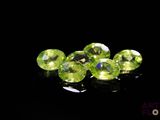 some very pretty green gems on a black surface