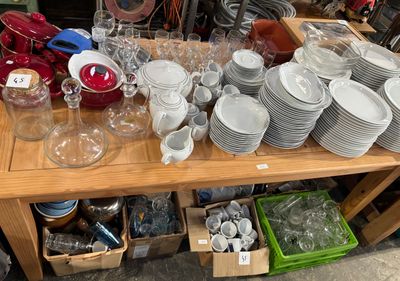 a wooden table with a lot of dishes and cups on it
