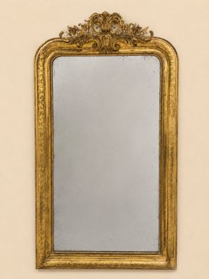 un miroir ancien dans un cadre doré accroché au mur d'une pièce
