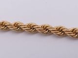 a close up of a gold chain on a white surface