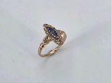 a close up of a gold ring with a blue stone in it
