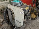 a machine that is sitting on the ground next to a pile of wood