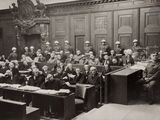 photographie en noir et blanc représentant un grand groupe de personnes assises dans une salle d'audience