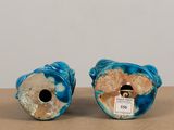 two blue vases sitting on top of a table next to each other