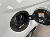 an electric car plugged into a charging station at a gas station
