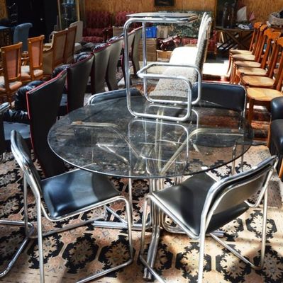 plusieurs chaises et une table dans une pièce où il y a un tapis au sol