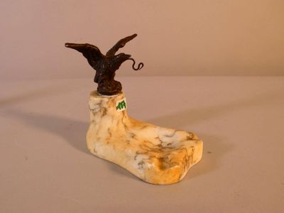 une figurine représentant un oiseau perché sur une chaussure