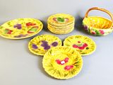 plusieurs assiettes et bols jaunes décorés de fleurs, ainsi qu'un panier en osier
