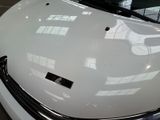 a close up of a white car with a sticker on it ' s hood