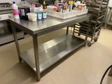 une grande table en acier inoxydable sur laquelle se trouvent de nombreux produits d'entretien