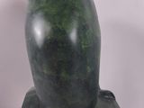 sculpture of a green owl on a black base