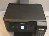une imprimante posée sur une table, à côté d'une autre imprimante