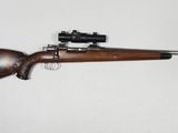 Gros plan sur un fusil équipé d'une lunette de visée, sur fond blanc