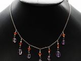 un collier composé de perles violettes et orange, porté par un mannequin