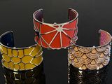 trois bracelets de couleur différente posés sur une surface noire