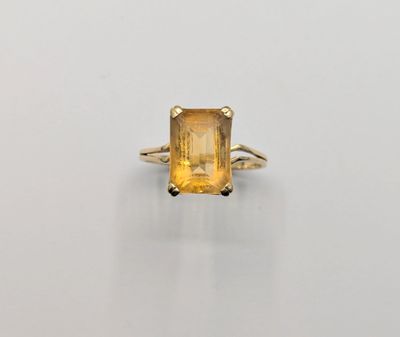 an image of a yellow sapphire ring on a white surface