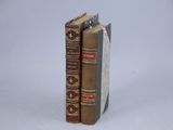 two books sitting on top of each other on a white surface