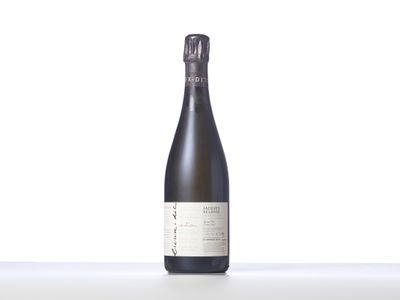 une bouteille de vin posée sur une table blanche