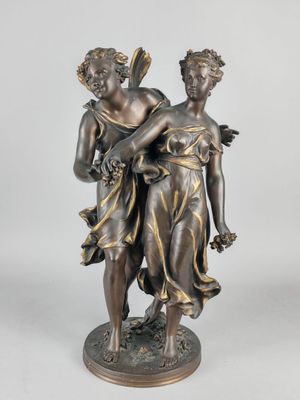 a bronze statue of two women holding flowers on a pedestal