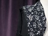 a close up of a black and white dress with white flowers on it