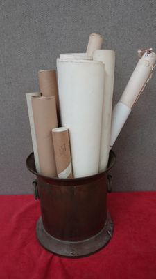 de nombreux rouleaux de papier dans un seau posé sur une table rouge