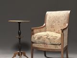 a chair that is next to a table with a lamp on it