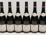 six bottles of wine are lined up in a row on a table