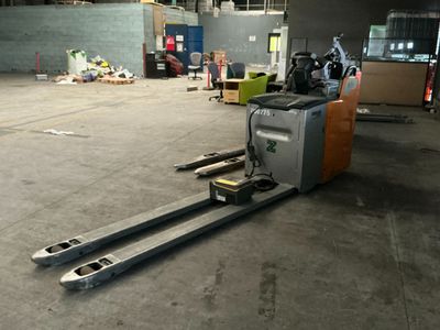 a forklift that is sitting in the middle of a warehouse