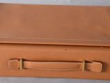 tan leather suitcase sitting on top of a white table